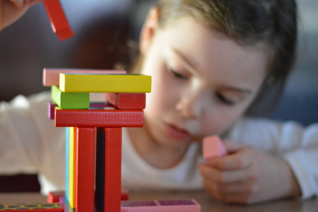 Integración sensorial y TDAH: niña concentrada en un juego de bloques durante terapia